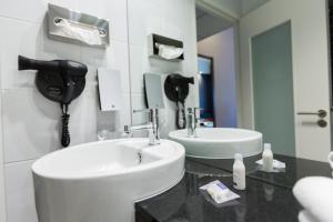 a bathroom with a sink and a phone on the wall at Holiday Inn Express - Marseille Airport by IHG in Vitrolles +19 photos