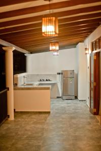 a large kitchen with a counter and a refrigerator at Sandun Villas in Unawatuna