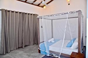 a room with a bed with a hanging canopy at Sandun Villas in Unawatuna