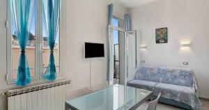 Una sala de estar con una mesa de cristal y un sofá. en Frida apartments, en San Remo