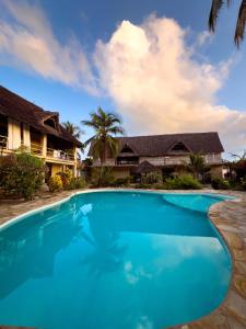 a swimming pool in front of a house at The Garden in Paje