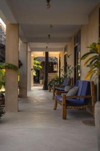a row of blue chairs sitting in a hallway at The Garden in Paje