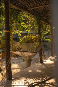 a hammock in the shade of a wooden structure at The Garden in Paje