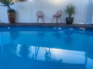two chairs sitting next to a swimming pool at Beachmere Palms Motel in Beachmere