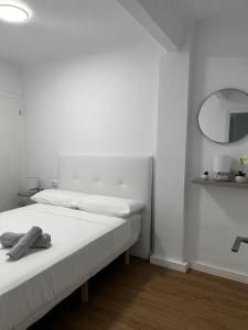 a white room with a bed and a mirror at Dúplex en Montanejos 200 metros del río Mijares in Montanejos