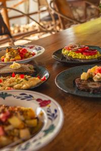 a wooden table with plates of food on it at The Garden in Paje