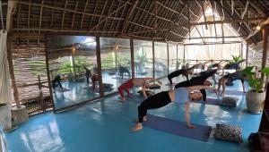 a group of people in a yoga class in the water at The Garden in Paje