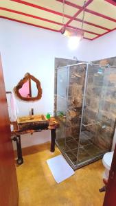 a bathroom with a sink and a glass shower at Hostal El Chili in Pijao