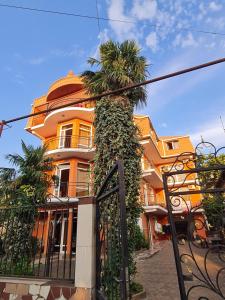 a palm tree in front of a building at Hotel Resanda in Kobuleti