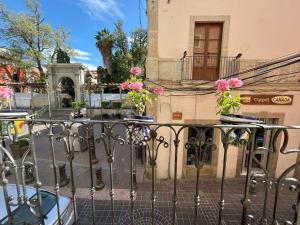 a wrought iron fence with flowers on the side of a building at Vista Reforma in Guanajuato