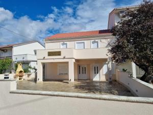 a large white house with a driveway at Moco - Novalja in Novalja