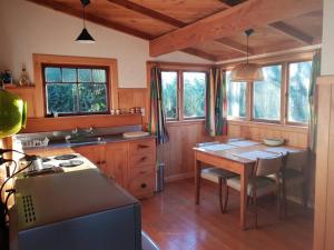 a kitchen with a wooden table and a wooden floor at Blue Cottage in Pohara