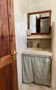 a bathroom with a sink and a mirror at The Garden in Paje