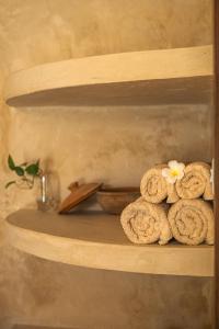 a shelf with towels and a flower on it at The Garden in Paje