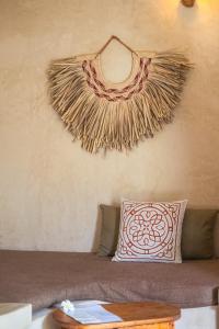 a couch with a pillow and a wall with a scarf at The Garden in Paje