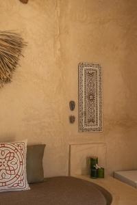 a room with a bed with a wall with a stencil on it at The Garden in Paje