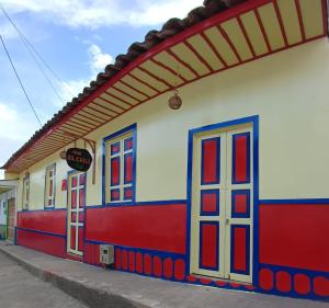 a colorful building with doors and windows on a street at Hostal El Chili in Pijao +47 photos