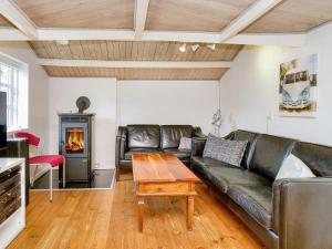 a living room with a leather couch and a fireplace at 9 person holiday home in Jægerspris-By Traum in Jægerspris