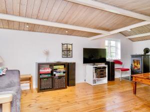 a living room with a couch and a tv at 9 person holiday home in Jægerspris-By Traum in Jægerspris