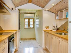 a kitchen with wooden cabinets and a sink at 9 person holiday home in Jægerspris-By Traum in Jægerspris
