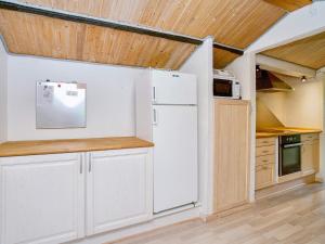 a kitchen with white appliances and wooden ceilings at 9 person holiday home in Jægerspris-By Traum in Jægerspris