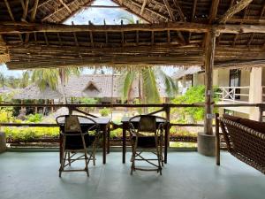 a table and chairs in a room with a view at The Garden in Paje