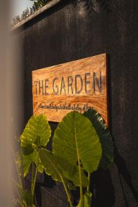 a sign that says the garden next to a plant at The Garden in Paje