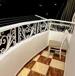 マンスーラにあるluxury Hotel Apartment, Mansouraの床のあるバルコニーに置かれた白い椅子