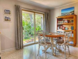 ein Esszimmer mit Tisch und Stühlen und einem Fenster in der Unterkunft Cute Cottage with 3 min walk to beach with bikes! in Jekyll Island