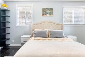 a bedroom with a bed and two windows at Chic Victorian Oasis - Oakland Heart in Oakland