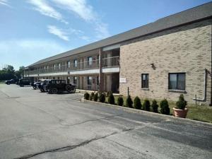 Un edificio de ladrillo con coches aparcados delante. en Hoosier Inn- Portland, en Portland