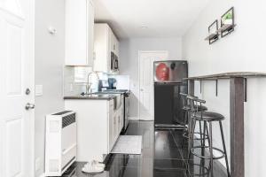 a kitchen with white cabinets and a black refrigerator at Chic Victorian Oasis - Oakland Heart in Oakland