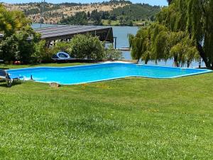une grande piscine dans un jardin avec un lac dans l'établissement Costa del Sol de Rapel, à La Estrella