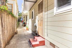 an alley between two buildings with red steps on the side at Chic Victorian Oasis - Oakland Heart in Oakland