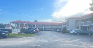 un parcheggio con auto parcheggiate davanti a un edificio di Motel 6 Abbeville, AL ad Abbeville