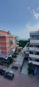 eine Stadtstraße mit auf einem Parkplatz geparkten Autos in der Unterkunft Kompleksi FISHTA kulla 6 in Velipojë