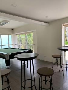 a room with a ping pong table and some stools at Mountain Views Studio Two Dumaguete in Dumaguete