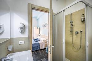 a bathroom with a shower and a bedroom with a bed at Il Viaggiator Leggero in Florence