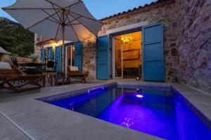 a swimming pool with an umbrella next to a house at Family friendly house with a swimming pool Cove Zarace, Hvar - 23502 in Hvar