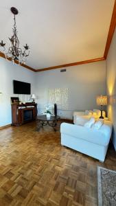 a living room with a white couch and a piano at Montecito Cottage in Santa Barbara