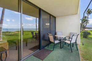 a patio with a table and chairs and a view of the ocean at Sugar Beach Resort, #130 condo in Kihei