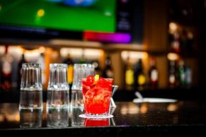 a red drink in a glass sitting on a bar at Camino Real Acapulco Diamante in Acapulco +90 photos