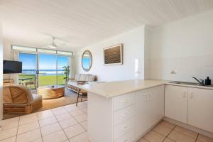 a kitchen and living room with a view of the ocean at Absolute Beachfront Apartment 11B in Lennox Head