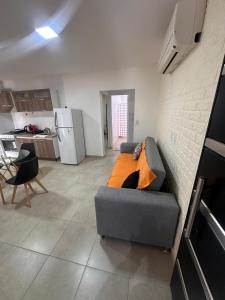 a living room with a couch and a kitchen at Departamentos del Norte in Fray Luis Beltrán +11 photos