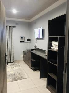 a room with a desk with a computer and a television at Kwakwethu in Bulawayo