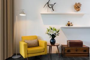 a yellow chair and a vase of flowers in a room at Viroth's Hotel in Siem Reap