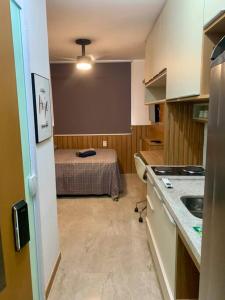 a small kitchen with a bed in a room at Studio aconchegante! in Salvador