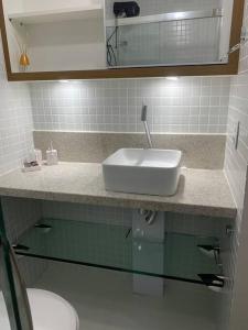 a bathroom counter with a sink and a toilet at Studio aconchegante! in Salvador