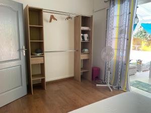 Habitación con armario, nevera y puerta. en Sarithea, en Basse-Terre