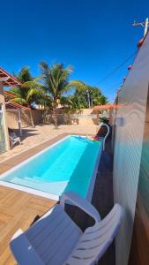 a swimming pool with two lounge chairs next to a house at Cantinho da Bell in Araruama